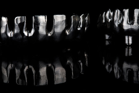 composition of titanium dental beams on black glass with reflectionの写真素材