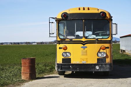 School bus and rusty trash can