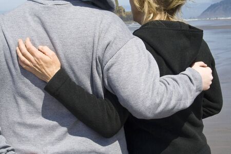 A mother and daughter embracing on a cold day