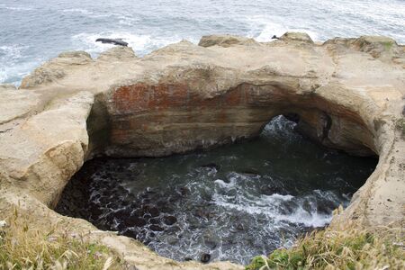 A punch bowl rock formation on the Pacific coastの写真素材