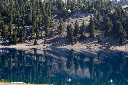PIne trees reflected in Lake Helen at Lassen Volcanic National Parkの写真素材