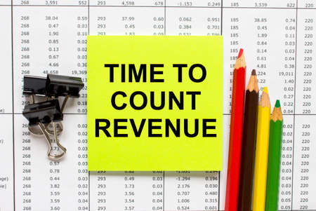 Text Time To Count Revenue on financial tables with pen, glasses and paper clips. Business and...