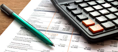 Financial Planning. Pen with a calculator on the background of tablesの写真素材