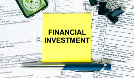 Text Financial Investment on note paper with pen, compass and paper clips. Business and financial conzeptの写真素材