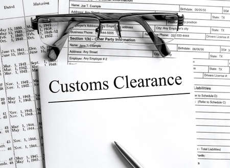 Paper with text Customs Clearance on a financial tables with glasses. Business and financial conzeptの写真素材
