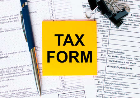 Text Tax Form on note paper with pen and glasses. Business and financial conzeptの写真素材
