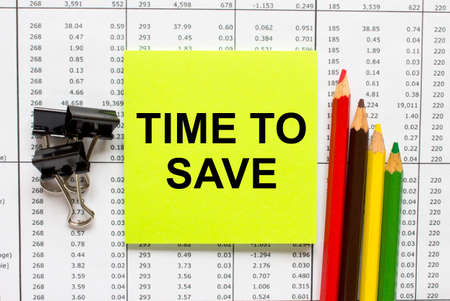 Text Time To Save on financial tables with pencils, glasses and paper clips. Business and financial conzeptの写真素材