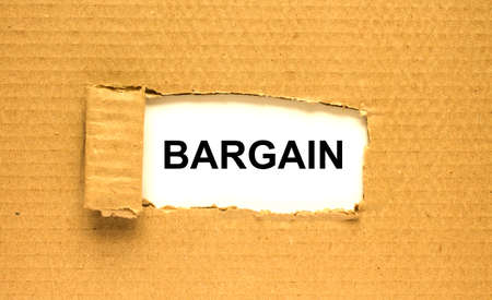The text Bargain appearing behind torn brown paperの写真素材