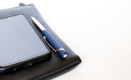 Black leather wallet with pen and mobile phoneの写真素材