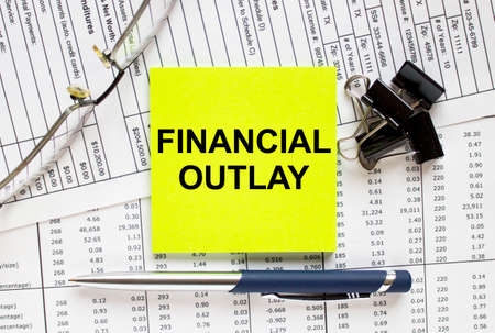 Text Financial Outlay on financial tables with pen, glasses and paper clips. Business and financial conzeptの写真素材