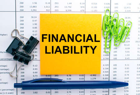 Text Financial Liability on financial tables with pen and paper clips. Business and financial conzeptの写真素材