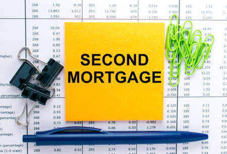 Text Second Mortgage on financial tables with pen, glasses and paper clips. Business and financial conzeptの写真素材