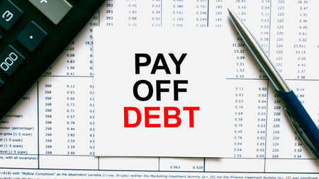 Work smarter text Pay Off Debt on white sheet with pen, calculator and tablesの写真素材
