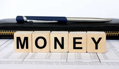 A word Money written in a wooden cube with a pen and purseの写真素材
