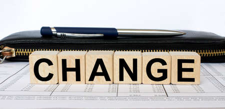 A word Change written in a wooden cube with a pen and wallet. Business and financial conzeptの写真素材