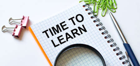 Notepad with text Time To Learn on white background with clips, pen and magnifying glassの写真素材