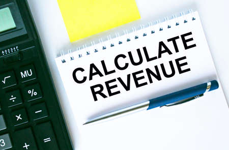 Notepad with text Calculate Revenue. Calculator, pen and stickers. Business and financial conceptの写真素材