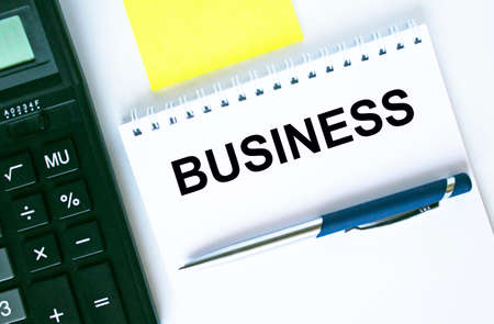 Notepad with text Business. Calculator, pen and stickers. Business and financial conceptの写真素材