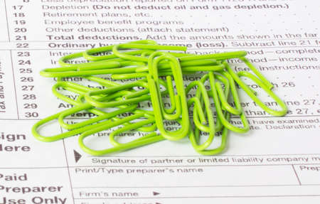 A green paper clips sits on the financial tables. Business and financial conceptの写真素材
