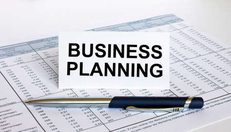 Text Business Planning on white card with blue metal pen on financial table. Business and financial conceptの写真素材