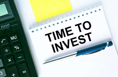 Notepad with text Time To Invest. Calculator, pen and stickers. Business and financial conceptの写真素材