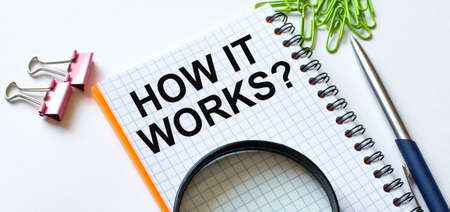 Notepad with text How it works on white background with clips, pen and magnifying glassの写真素材
