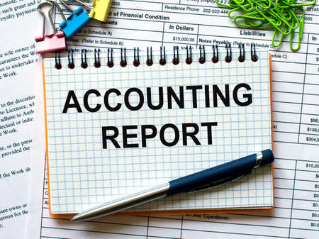 Notepad with text Accounting Report on white background with paper clips and penの写真素材