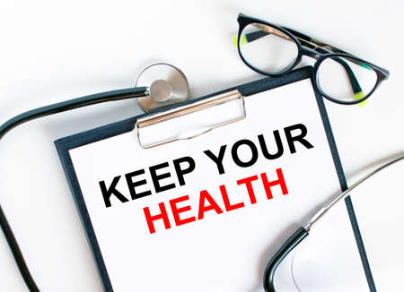 Text Keep Your Health in the folder with the stethoscope and glasses. Medical concept photoの写真素材