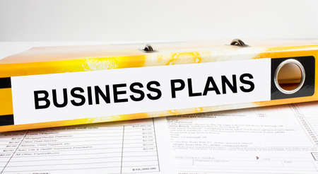 Text Business Plans on the folder that is located on the financial reports. Business and financial conceptの写真素材