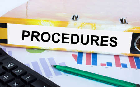 Text Procedures on the folder that is located on the financial diagrams with green pen and calculator. Business and financial conceptの写真素材