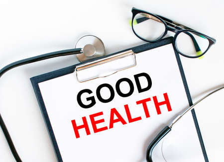 Text Good Health in the folder with the stethoscope and glasses. Medical concept photoの写真素材