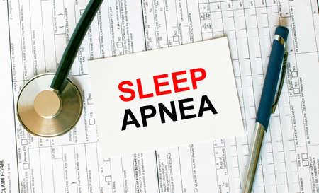 Text Sleep Apnea on the white card with the stethoscope, pen and medical documents. Medical concept photoの写真素材