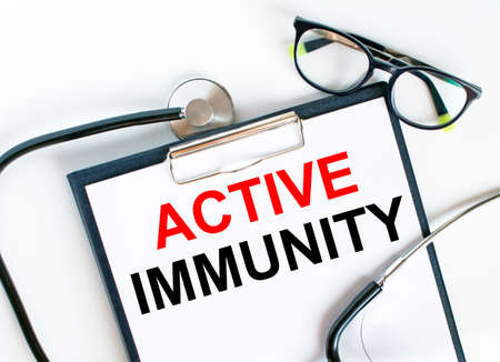 Text Active Immunity in the folder with the stethoscope and glasses. Medical concept photoの写真素材