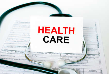Text Keep Health Care on the white card with the stethoscope and medical documents. Medical concept photoの写真素材