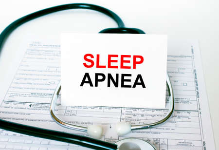 Text Sleep Apnea on the white card with the stethoscope and medical documents. Medical concept photoの写真素材