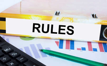 Text Rules on the folder that is located on the financial diagrams with green pen and calculator. Business and financial conceptの写真素材