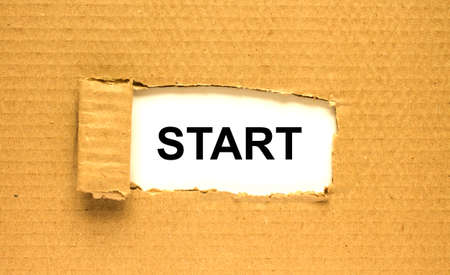 The word Start appearing behind torn brown paper. Can be use as a concept photoの写真素材