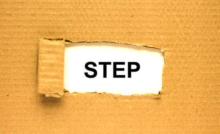 The word Step appearing behind torn brown paper. Can be use as a concept photoの写真素材