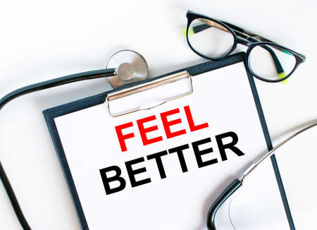 Text Feel Better in the folder with the stethoscope and glasses. Medical concept photoの写真素材