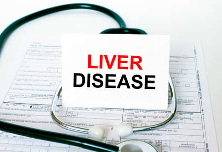 Text Liver Disease on the white card with the stethoscope and medical documents. Medical concept photoの写真素材