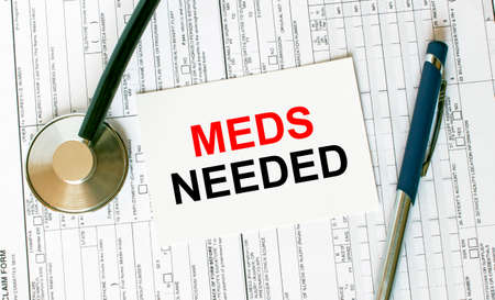 Text Meds Needed on the white card with the stethoscope, pen and medical documents. Medical concept photoの写真素材