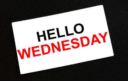 White card on the black background with text Hello Wednesday. Concept photoの写真素材