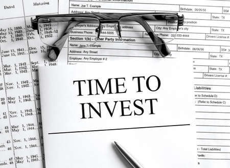 Paper with text Time To Invest on a financial table with eyeglasses and metal pen. Financial and concept photoの写真素材
