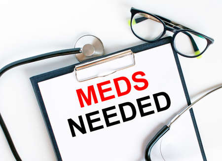 Text Meds Needed in the folder with the stethoscope and glasses. Medical concept photoの写真素材