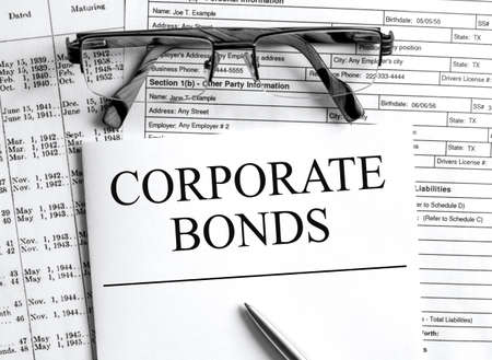Paper with text Corporate Bonds on a financial table with eyeglasses and metal pen. Financial and concept photoの写真素材