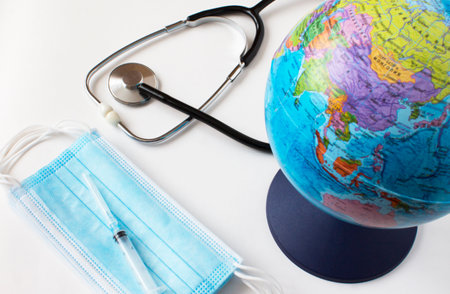 World globe with medical face mask and medical stethoscope. Pandemic concept, Virus, Coronavirus, Covid-19, international emergency, global quarantineの写真素材