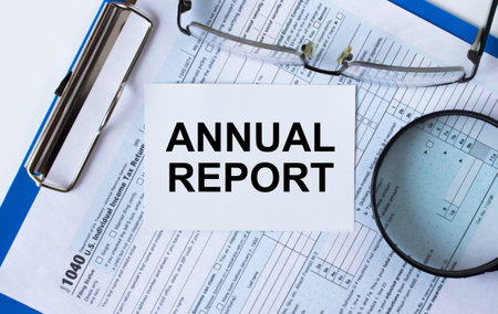 Business card with text Annual Report on Tax form 1040 with eyeglasses and magnifying glass. Financial conceptの写真素材
