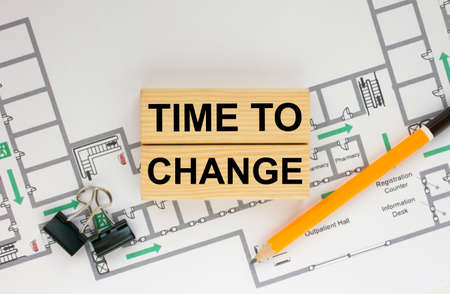 Construction drawings and wooden bars with text Time To Change and paper clips. Architecture and building concept.の写真素材