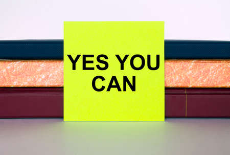 Yellow sticker Yes You Can on a stack of notebooks. Concept photoの写真素材