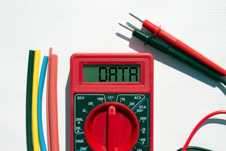 Multimeter with text on display Data and heat shrink insulation on white background. Construction and repairの写真素材